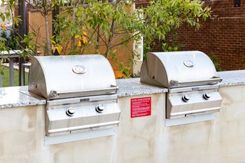 Two bbq grills on the side of a wall
